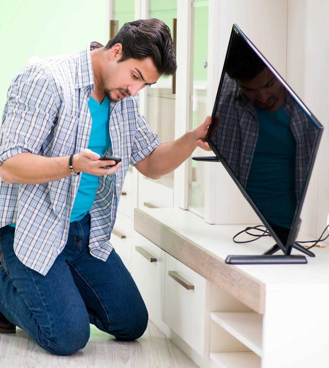 AR can assist consumers with DIY repairs to extend a product's life Man on smartphone to repair his television