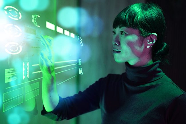 A woman illuminated in green light using an clear touch screen wall