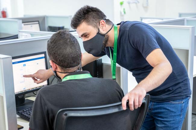 Better call center training Call center trainer and employee in masks
