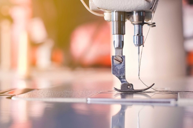 A sewing machine on a shop floor Close-up of sewing machine needle