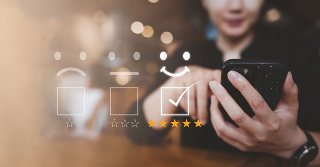 How empathy and technology can build customer loyalty Woman giving five star rating on her mobile phone