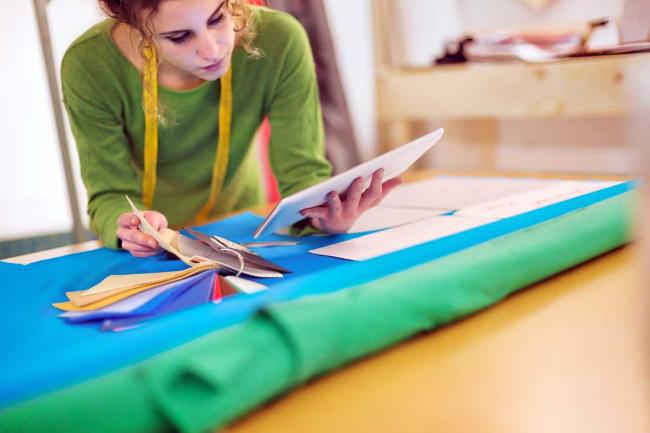 Fashion designer uses PLM for design, productivity and more Young fashion designer works on tablet