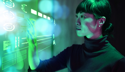 A woman illuminated in green light using an clear touch screen wall
