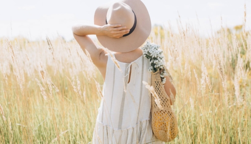Woman wearing eco-friendly fashionable dress made of organic cotton standing in a field
