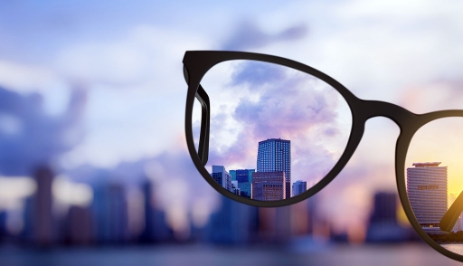 Image of eyeglasses bringing into focus a distant city