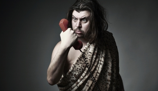 caveman holding a red telephone from the 90s illustrating the history of business process outsourcing