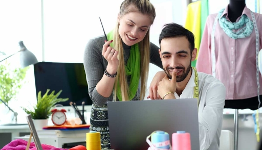 Two fashion designers work on computer
