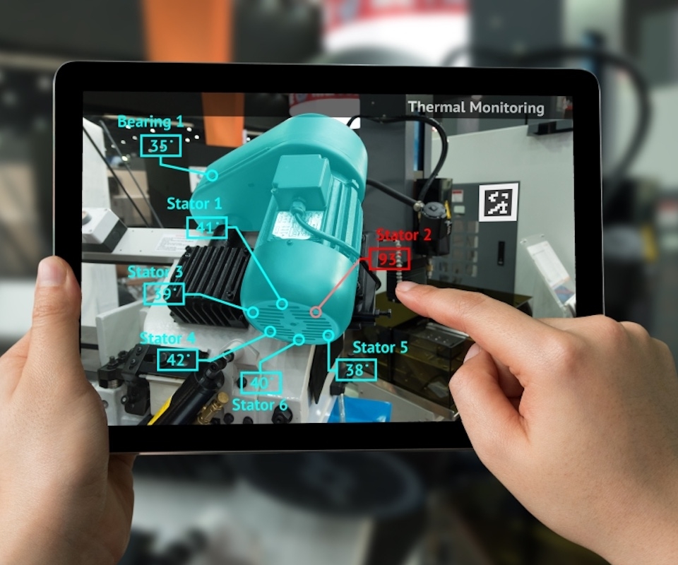 A technician uses TeamworkAR to inspect a motor on a digital tablet using augmented reality.